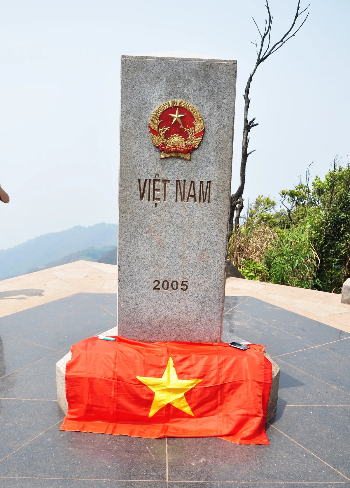 Cột mốc đá khắc chữ 'Việt Nam 2005' phủ cờ đỏ sao vàng trên đỉnh A Pa Chải, Điện Biên.